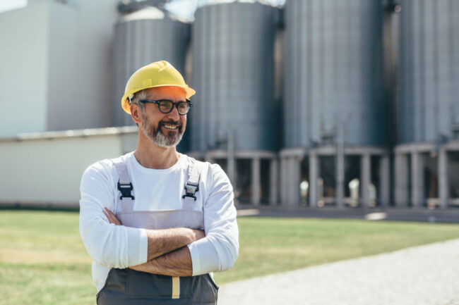 Worker in front of grain silos