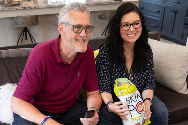 Man and woman eating Skinnypop popcorn