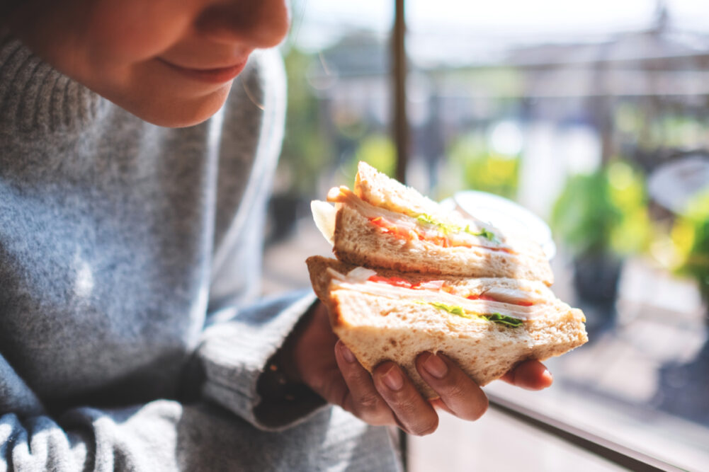 Woman eating whole grain wheat sandwich