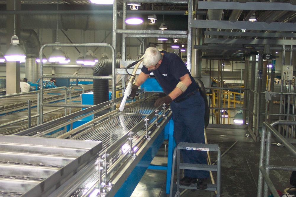 Man cleaning bakery equipment.