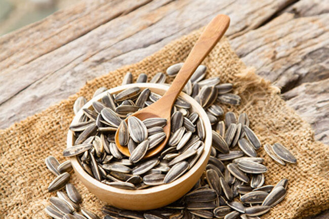 Sunflower seeds, wooden bowl, wooden spoon