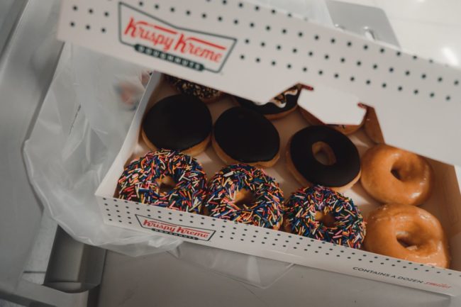 Box of assorted Krispy Kreme donuts.