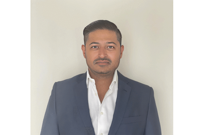 Ravi Thanawala stands for photograph in navy blazer and white button down shirt 