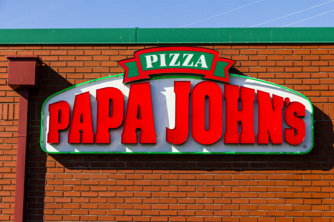 Papa Johns Logo over brick restaurant building. 