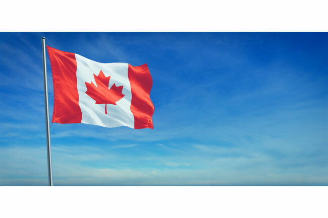 Candian flag blows in the wind on a beautiful sunny day. 