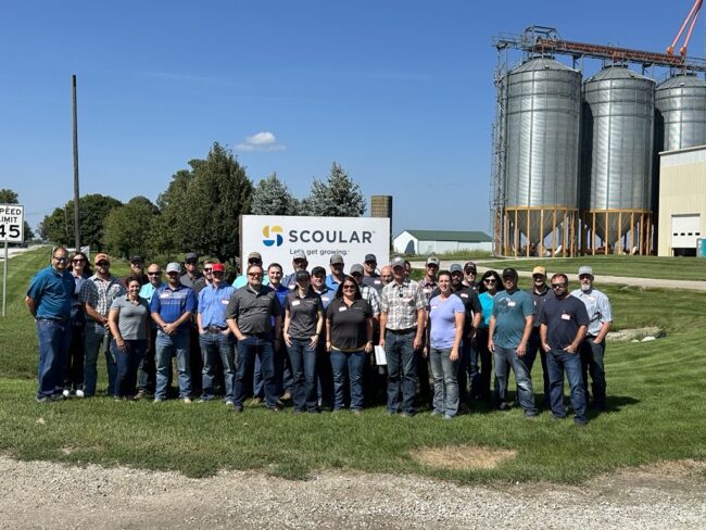 A group of Scoular employees stand outside of Illinois facility on sunny day. 