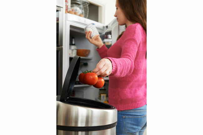 Woman throwing away old food. 