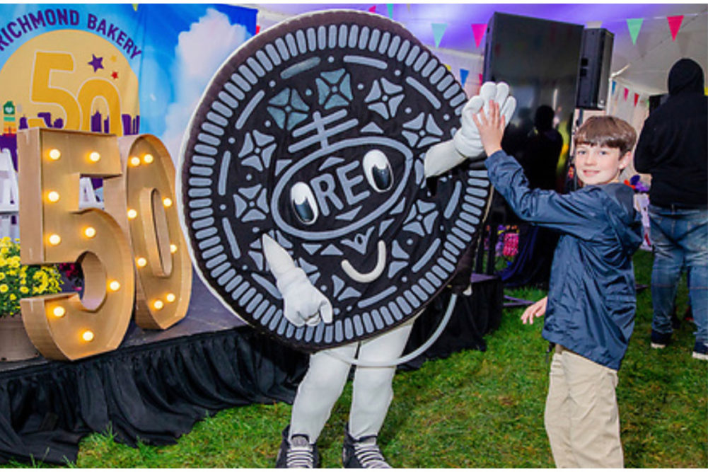 Oreo character high fives child at Mondelez celebration. 