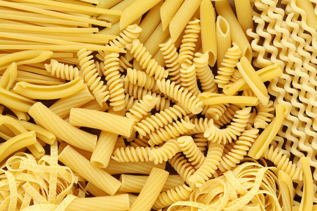 Assortment of uncooked pasta noodles including penne rigate and rotini.