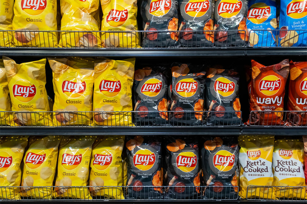 Assortment of Frito-Lay products on grocery store shelf. 