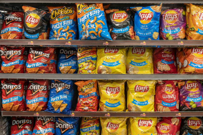 Assortment of Frito-Lay products on grocery store shelf. 