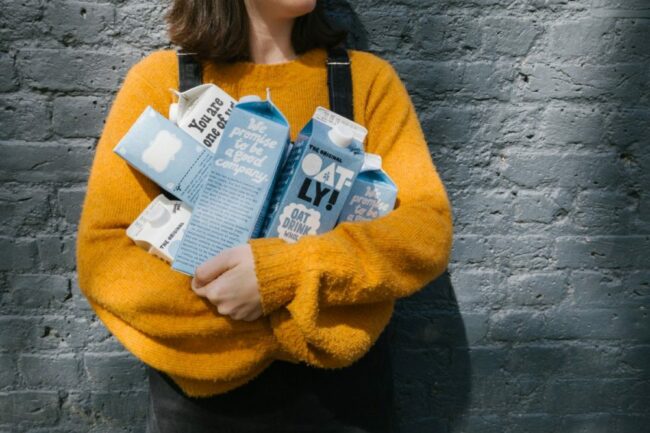 Woman holding Oatly Oat Milk.