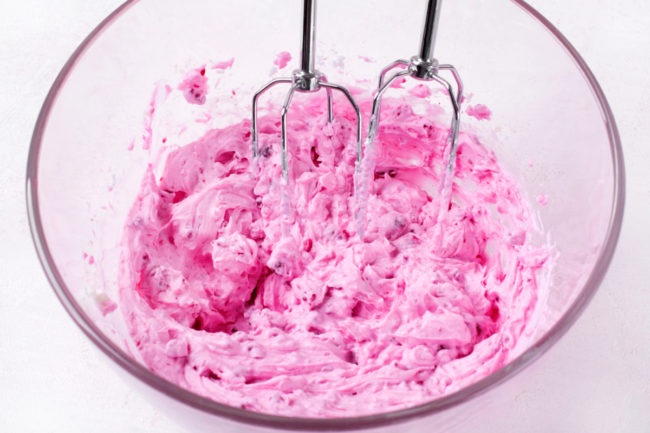 Whipped berry cream in mixing bowl. 
