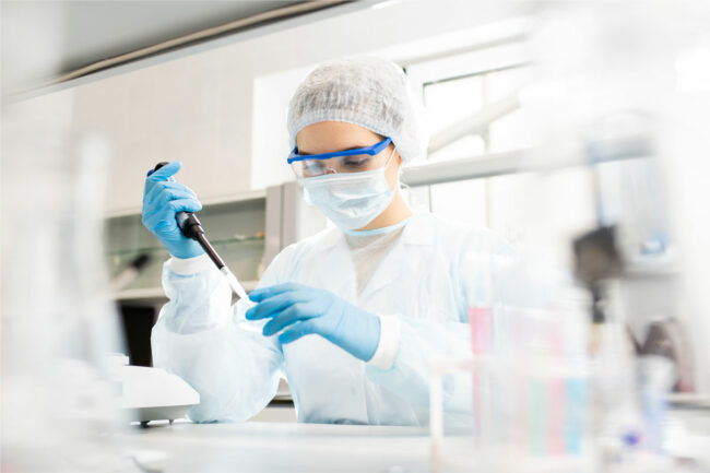 Woman employee tests a product in a food lab. 