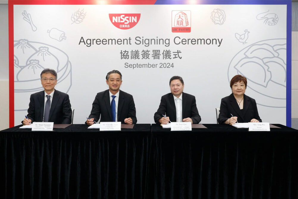 Nissin Foods board signing acquisition documents.