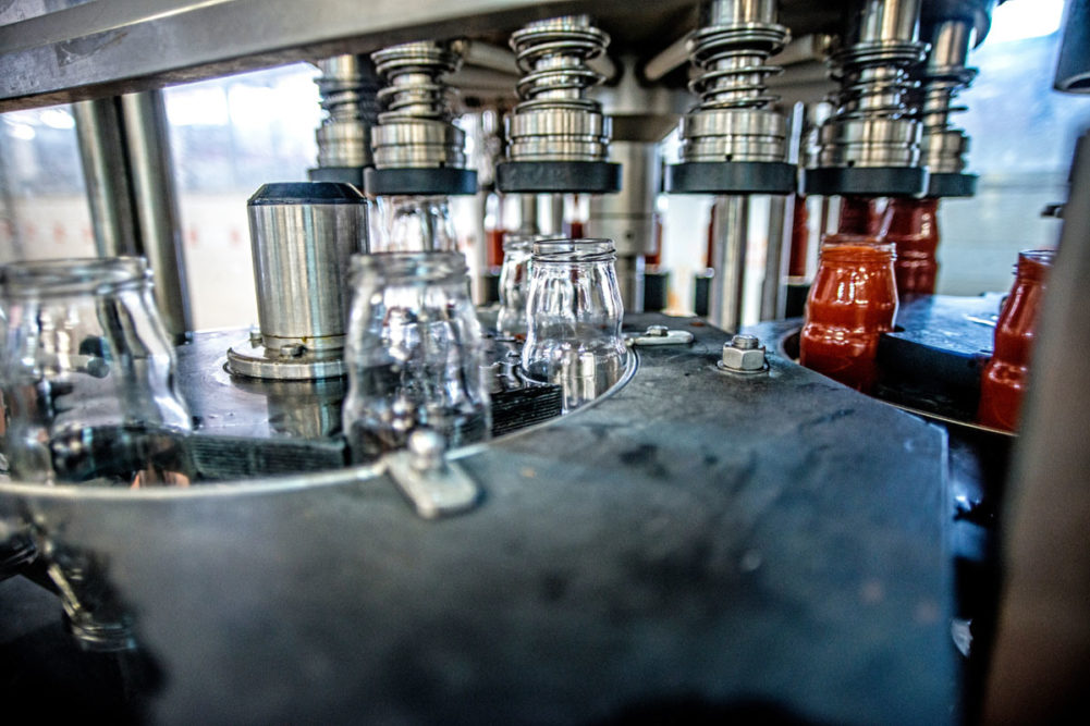 Bottles of sauce on assembly line. 