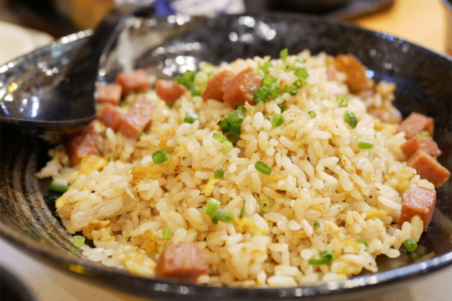 Japanese fried rice with ham in black bowl. 