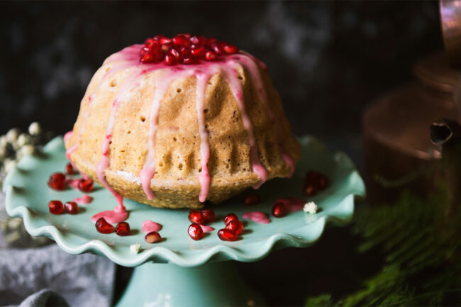 Cake topped with pomegranate seeds. 