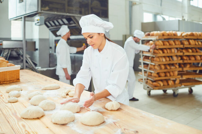 Woman works in bakery. 